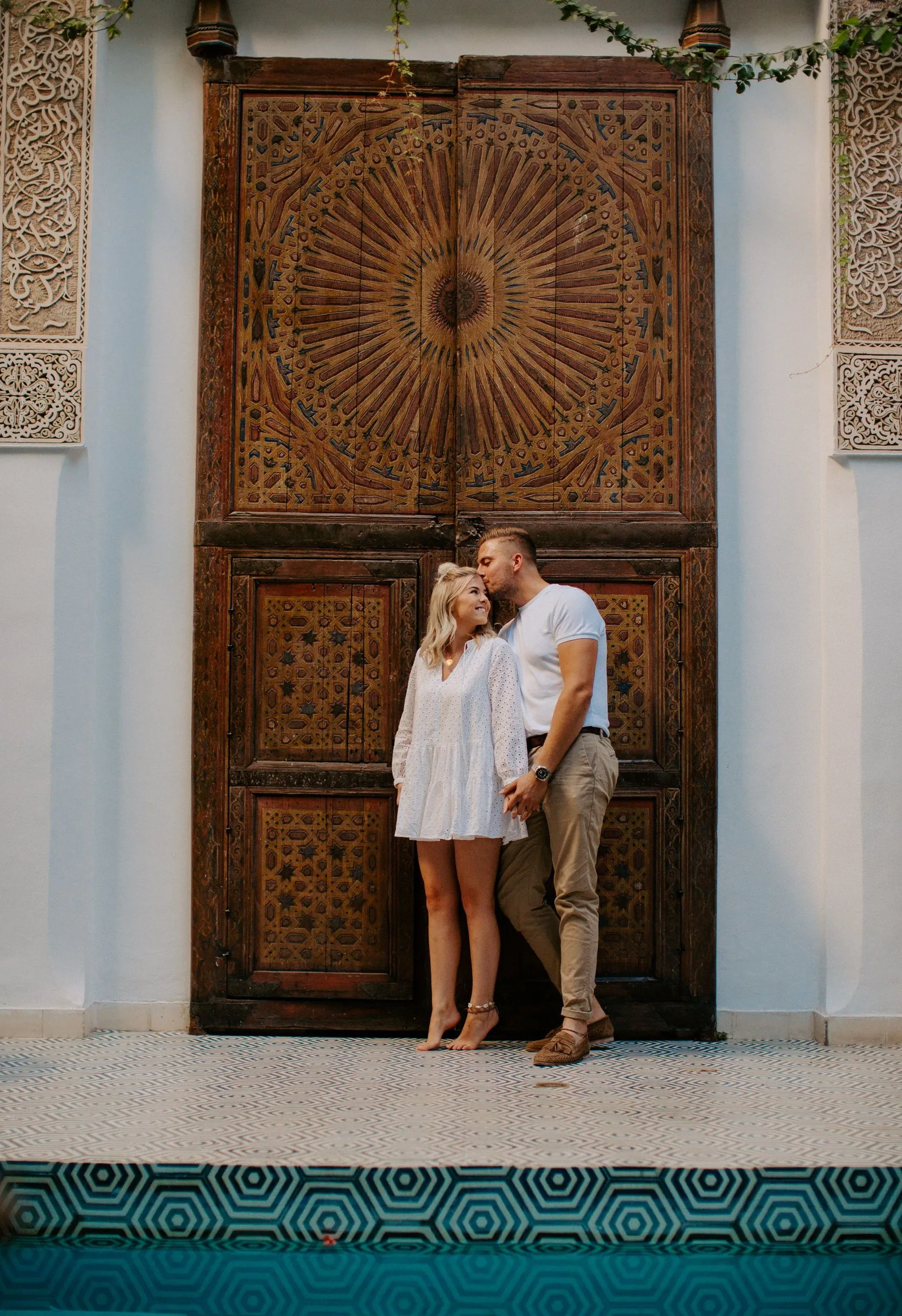 Un couple devant une porte sculptée